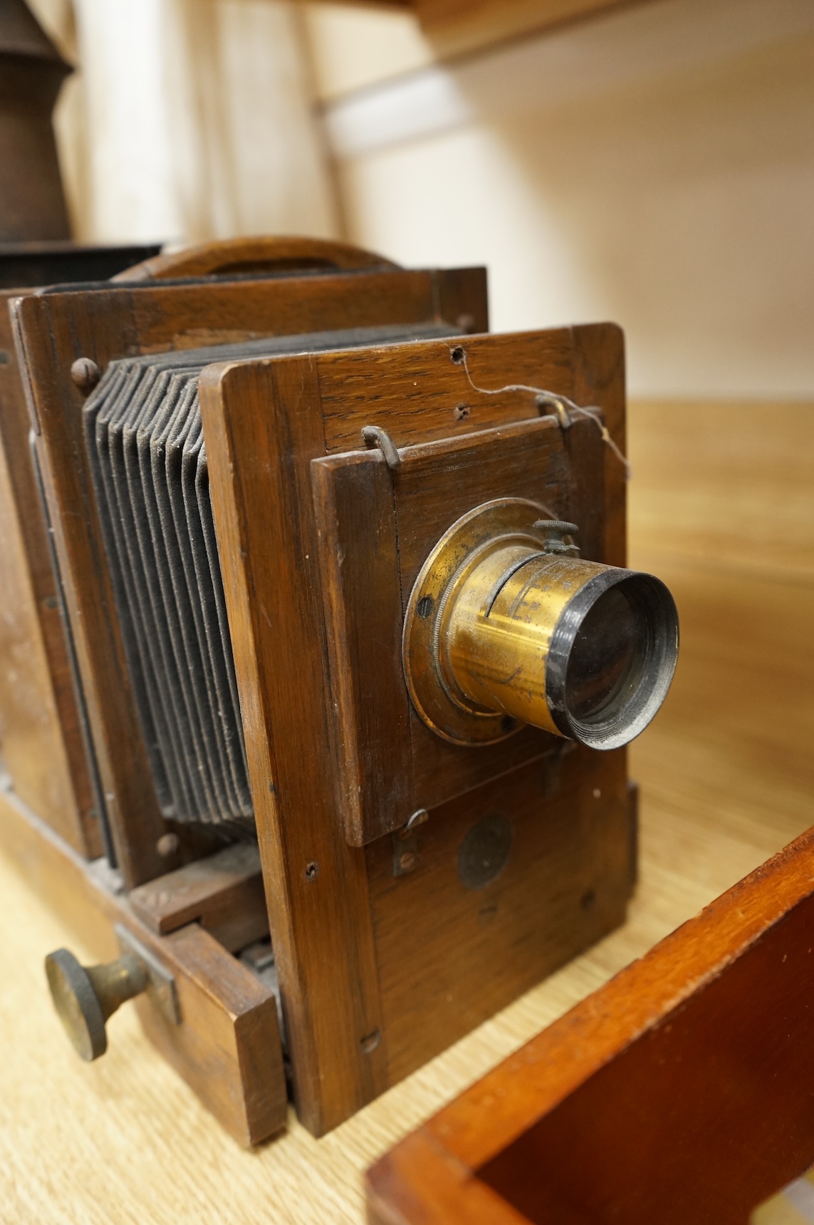 A late 19th century mahogany and tinplate magic lantern style horizontal photograph enlarger, together with some related items.